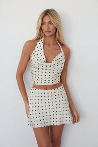 Woman wearing a polka dot dress against a white background