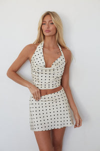 Woman wearing a polka dot dress against a white background