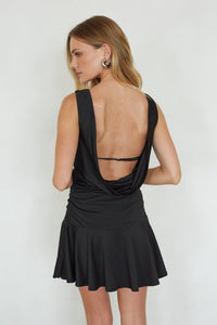 Black dress with open back worn by a person on a white background