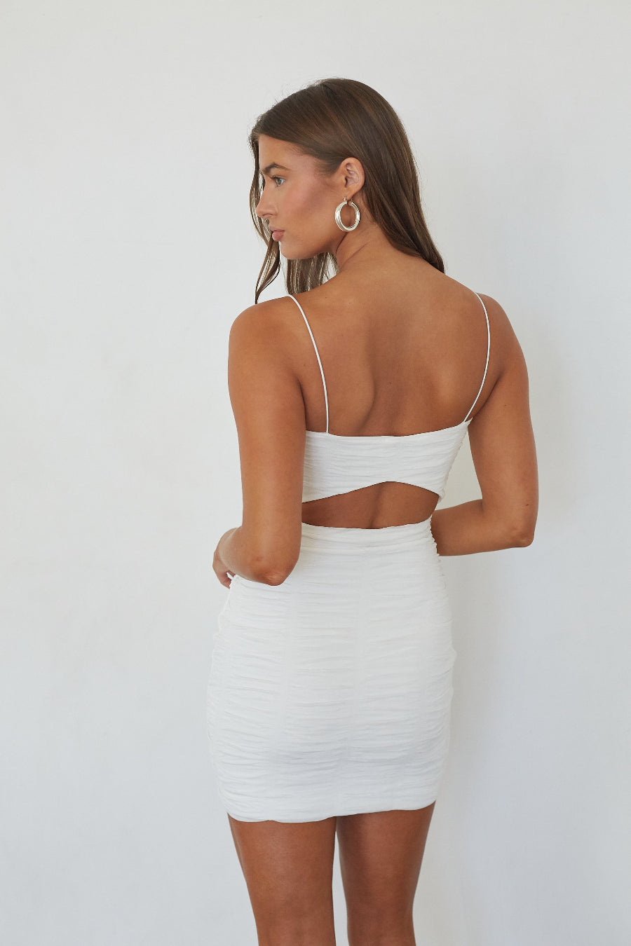 Model wearing the Lizeth Ruched Bodycon Mini Dress in white, back view