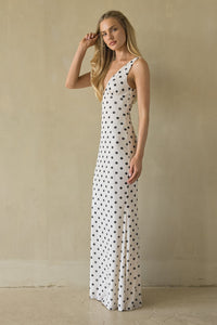 Woman wearing a polka dot dress against a beige wall