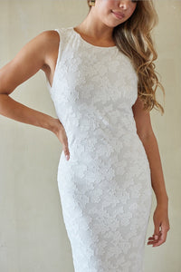 White lace dress worn by a person on a plain background