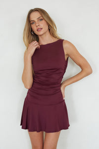 Woman wearing a burgundy dress against a white background