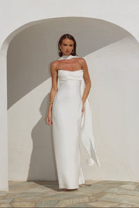 white-image | Woman in a white strapless gown standing against a neutral background