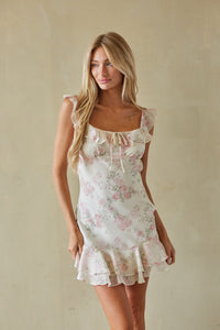 pink-image | Woman wearing a floral dress against a plain background