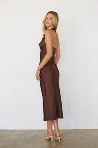 Woman wearing a brown dress against a white background