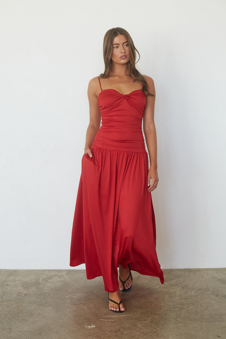 Red drop waist maxi dress, front view showing side pocket detail