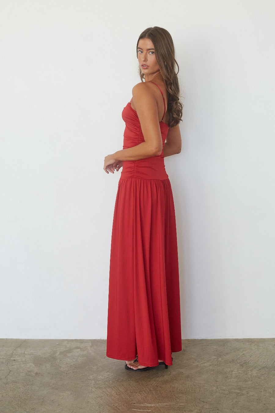 Red drop waist maxi dress, side profile view on model