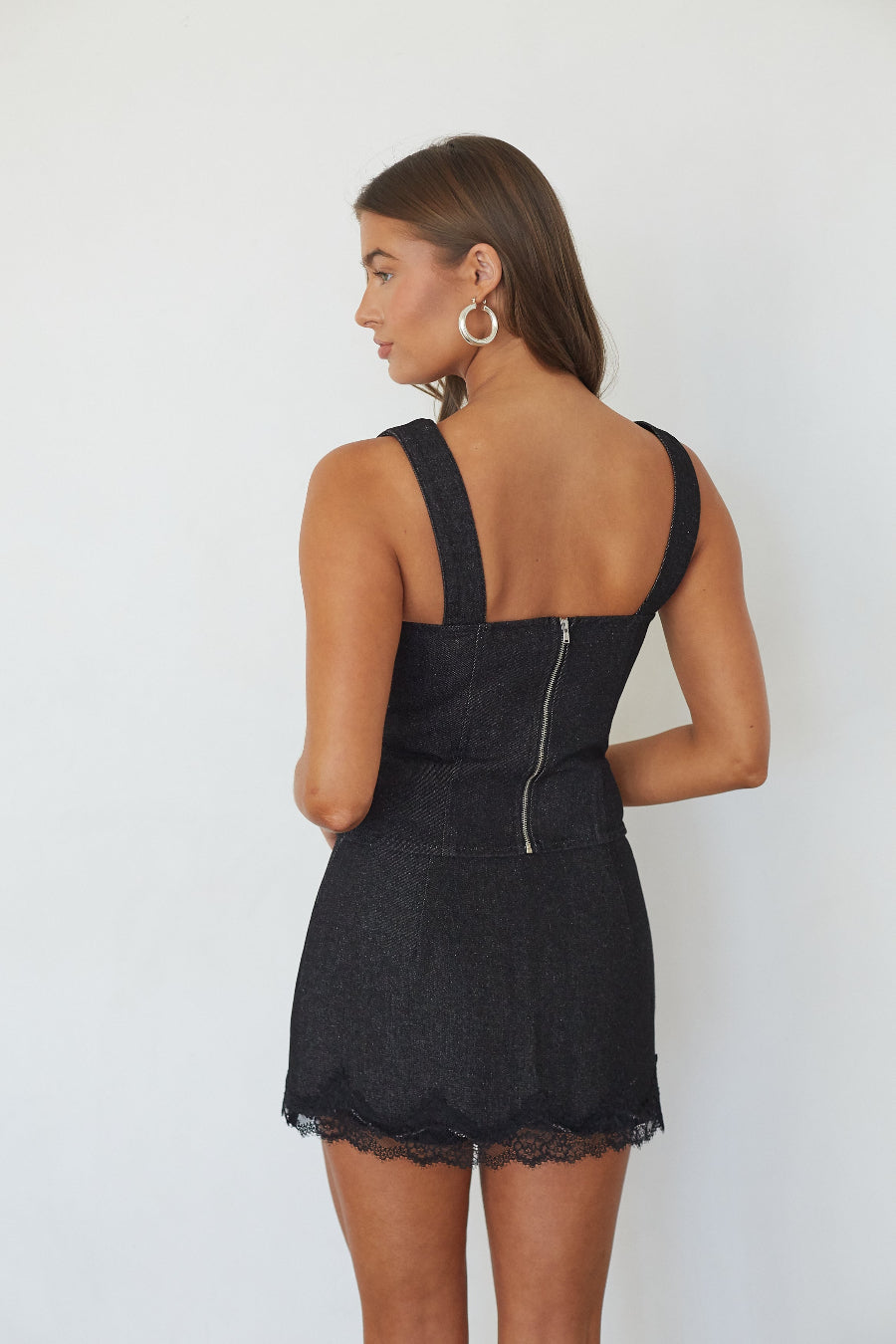 Black denim lace trim mini skort, back view on model