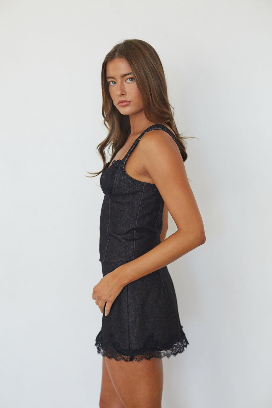 Black denim lace trim bustier top, side profile view on model