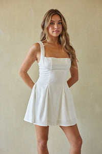Woman wearing a white dress against a plain background