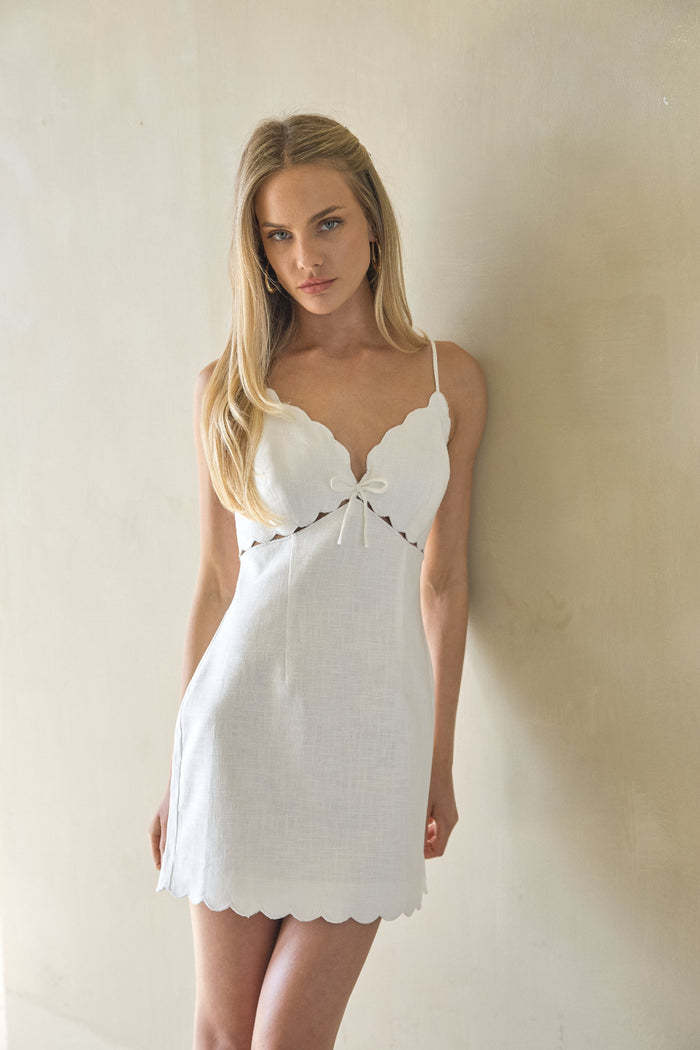 white-image | Woman wearing a white linen dress against a plain background