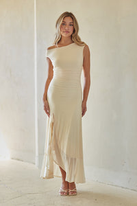 Woman wearing a white off-shoulder dress in a minimalistic setting