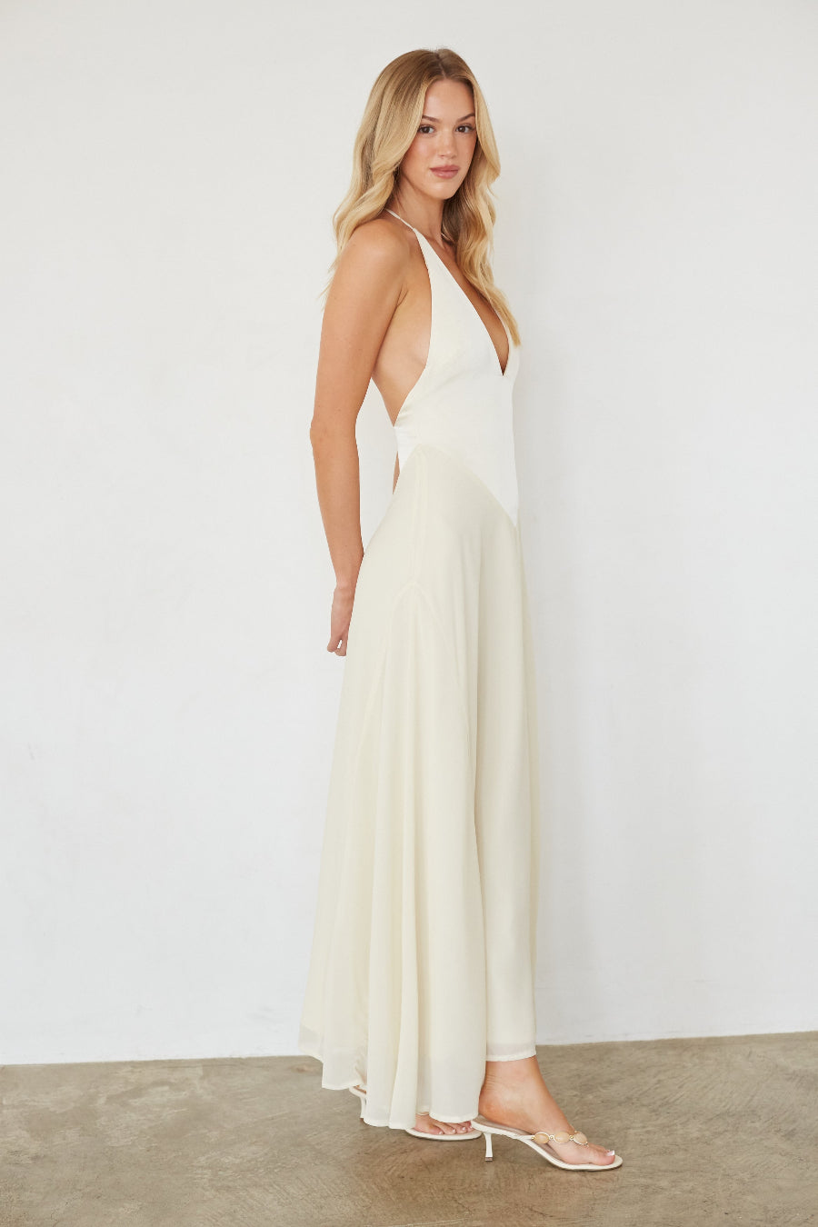 Woman wearing a white dress against a plain background