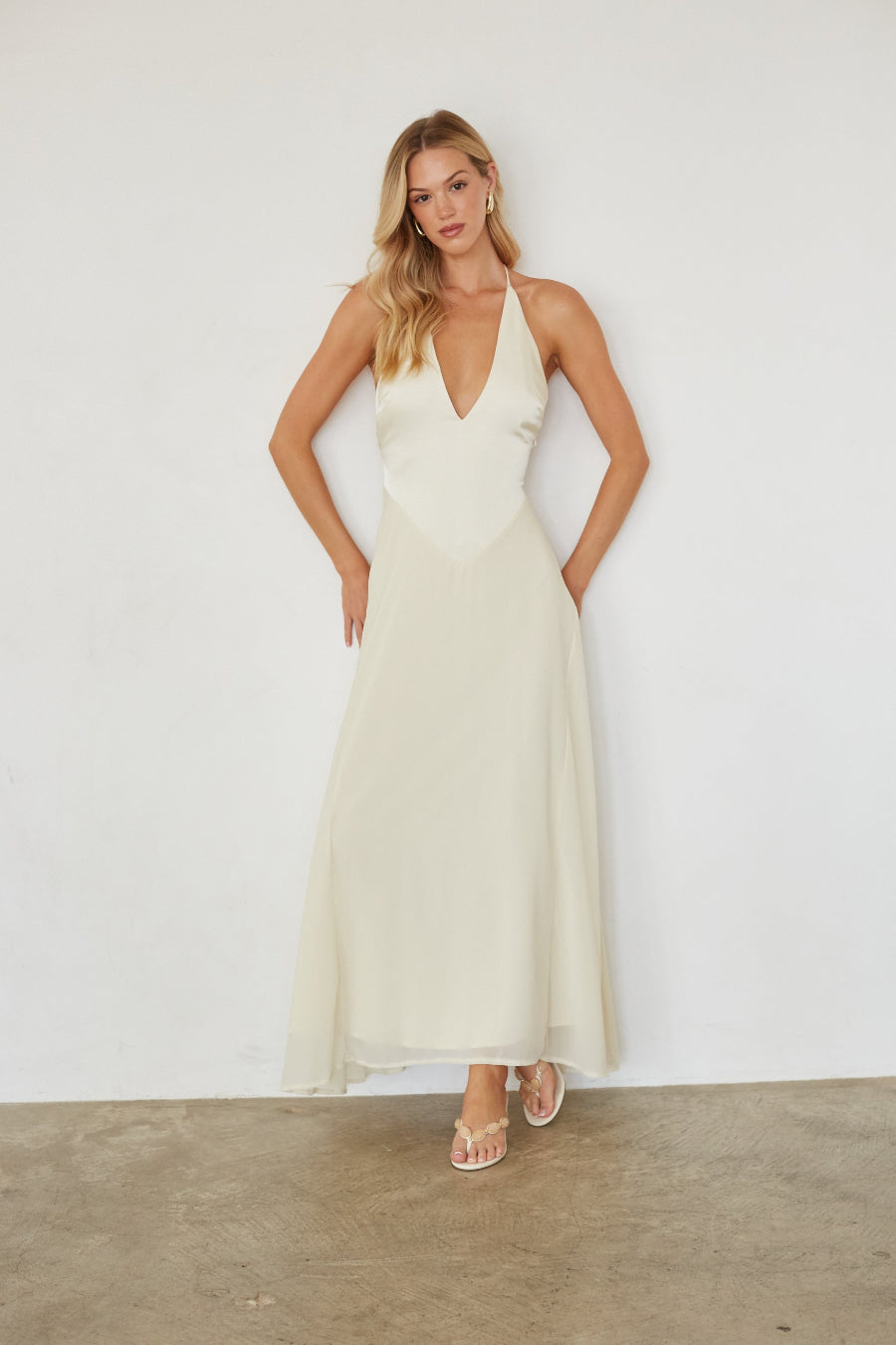 Woman wearing a white dress against a plain background