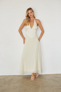 Woman wearing a white dress against a plain background