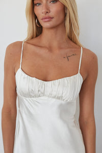 Woman wearing a white dress with a plain background