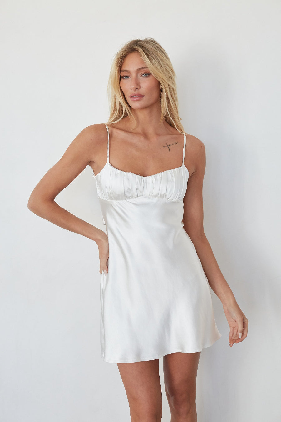 white-image | Woman wearing a white slip dress against a plain background