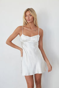 white-image | Woman wearing a white slip dress against a plain background