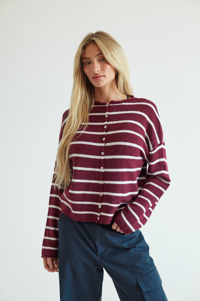 A blonde mode wearing a red and white striped button up sweater
