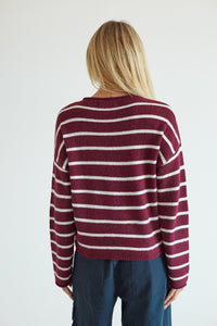back image of a blonde model in a red and white stripe sweater