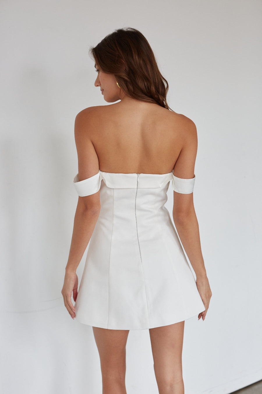 White strapless dress worn by a model on a plain background