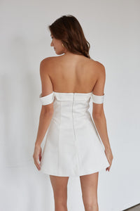 White strapless dress worn by a model on a plain background