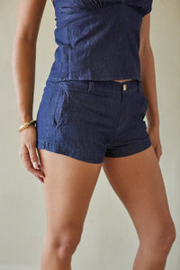 Person wearing a blue outfit with shorts and a top against a neutral background