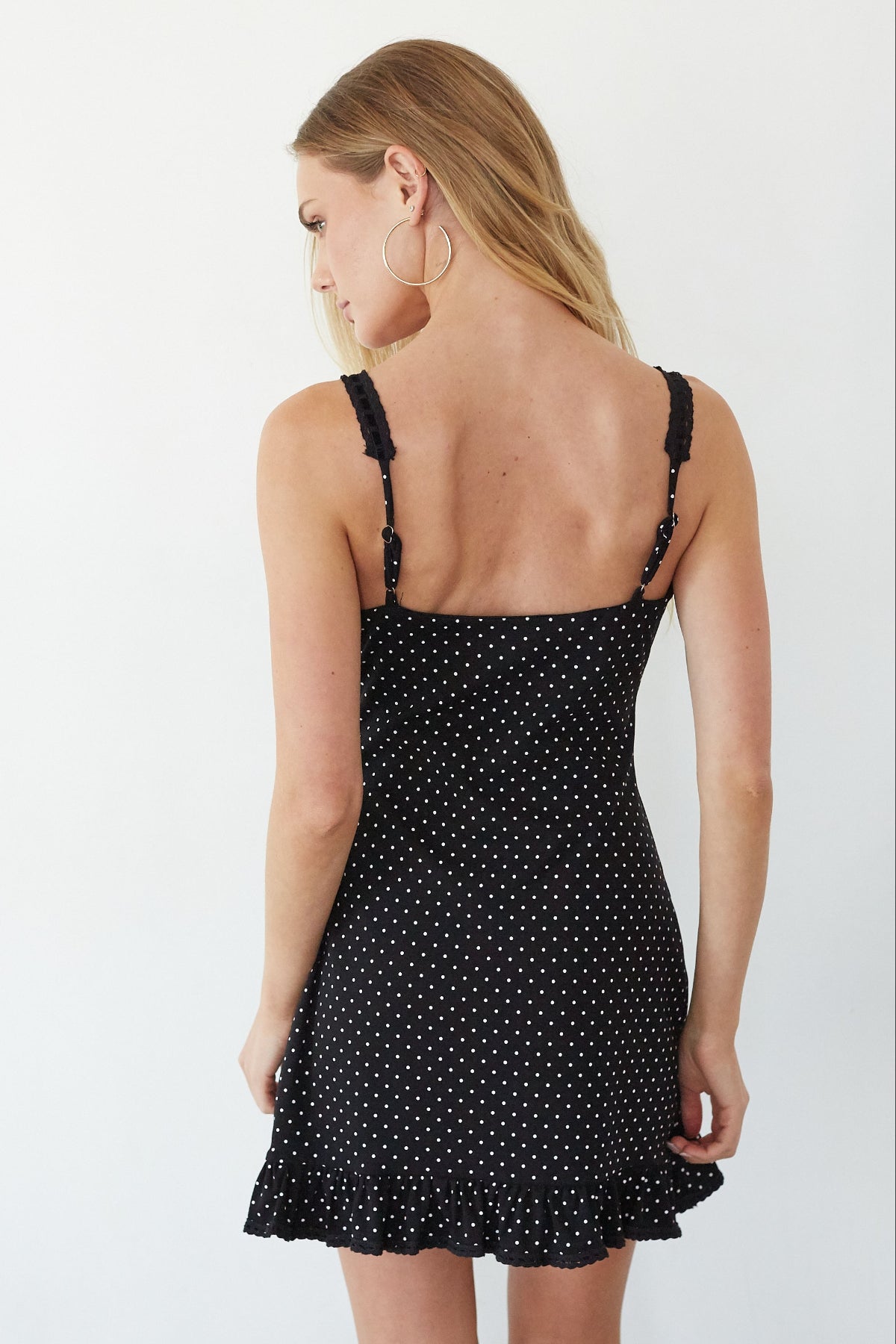 Woman wearing a black polka dot dress on a white background