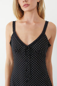 Black polka dot dress with lace details on a white background