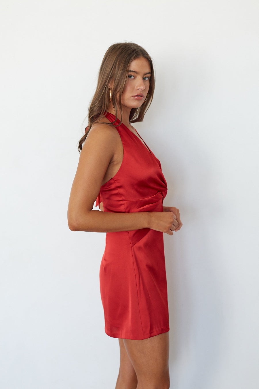 Red satin twist front mini dress, side profile view on model