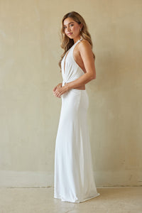 Woman wearing a white dress against a plain background