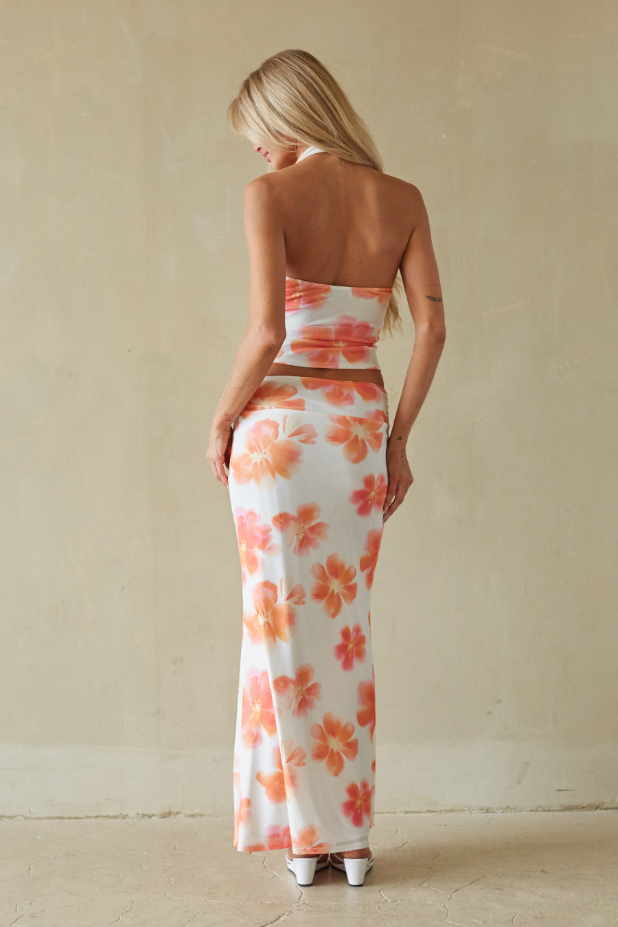 Woman wearing a strapless floral dress with a neutral background
