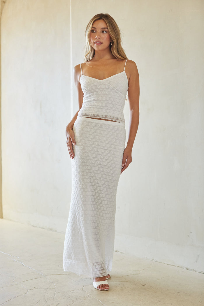 Woman wearing a white textured dress against a white background