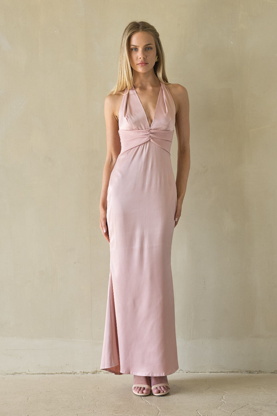 pink-image | Woman wearing a pink halter neck dress against a plain background
