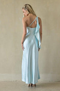 Woman wearing a light blue dress with a bow detail on a beige background