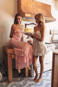 Two women in a kitchen with one holding a cake