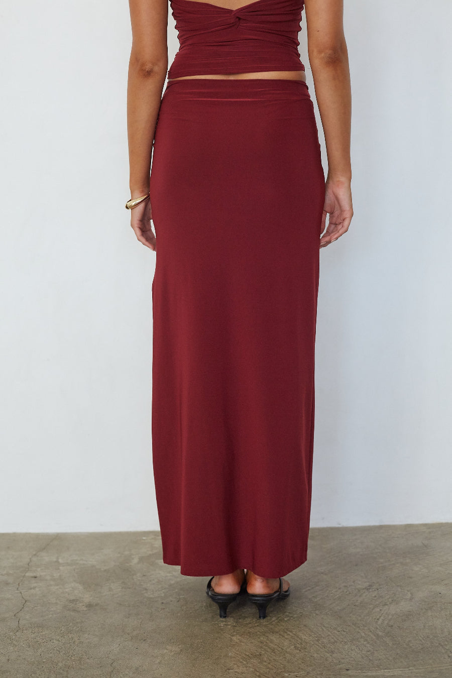 Burgundy ruched low waist maxi skirt, back view on model