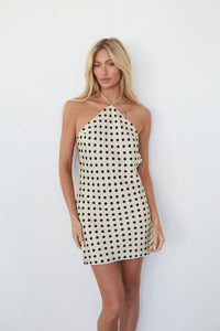 Woman wearing a polka dot dress against a white background