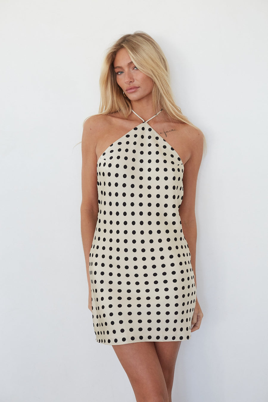 Woman wearing a polka dot dress against a white background