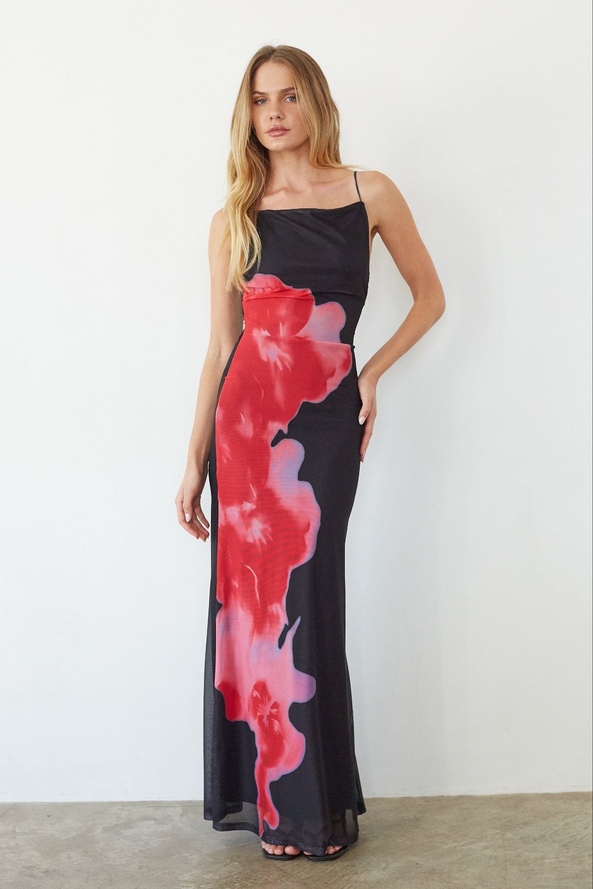 black-image | Woman wearing a black dress with red and pink abstract patterns against a white background