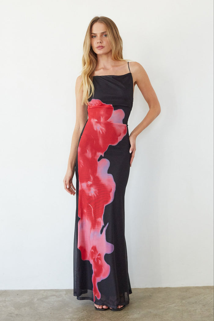 black-image | Woman wearing a black dress with red and pink abstract patterns against a white background