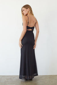 Woman wearing a black evening gown with cut-out design on a white background