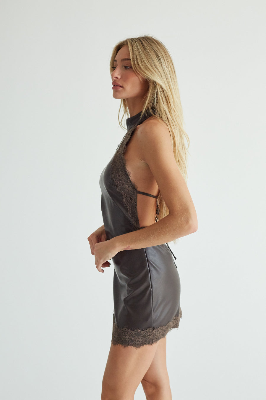 Brown faux leather lace trim mini dress, side profile view on model
