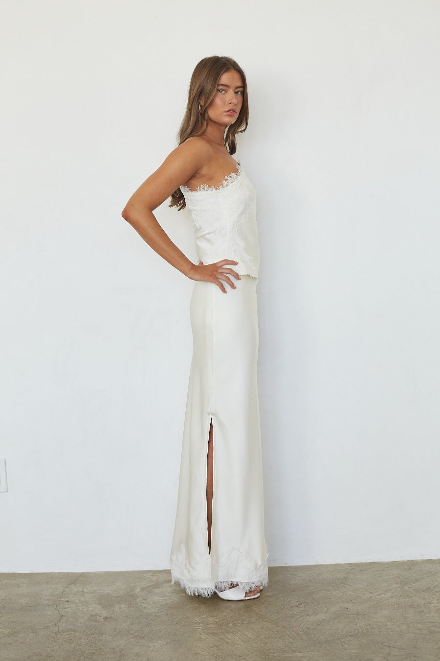 White satin lace trim maxi skirt, side profile view showing slit detail