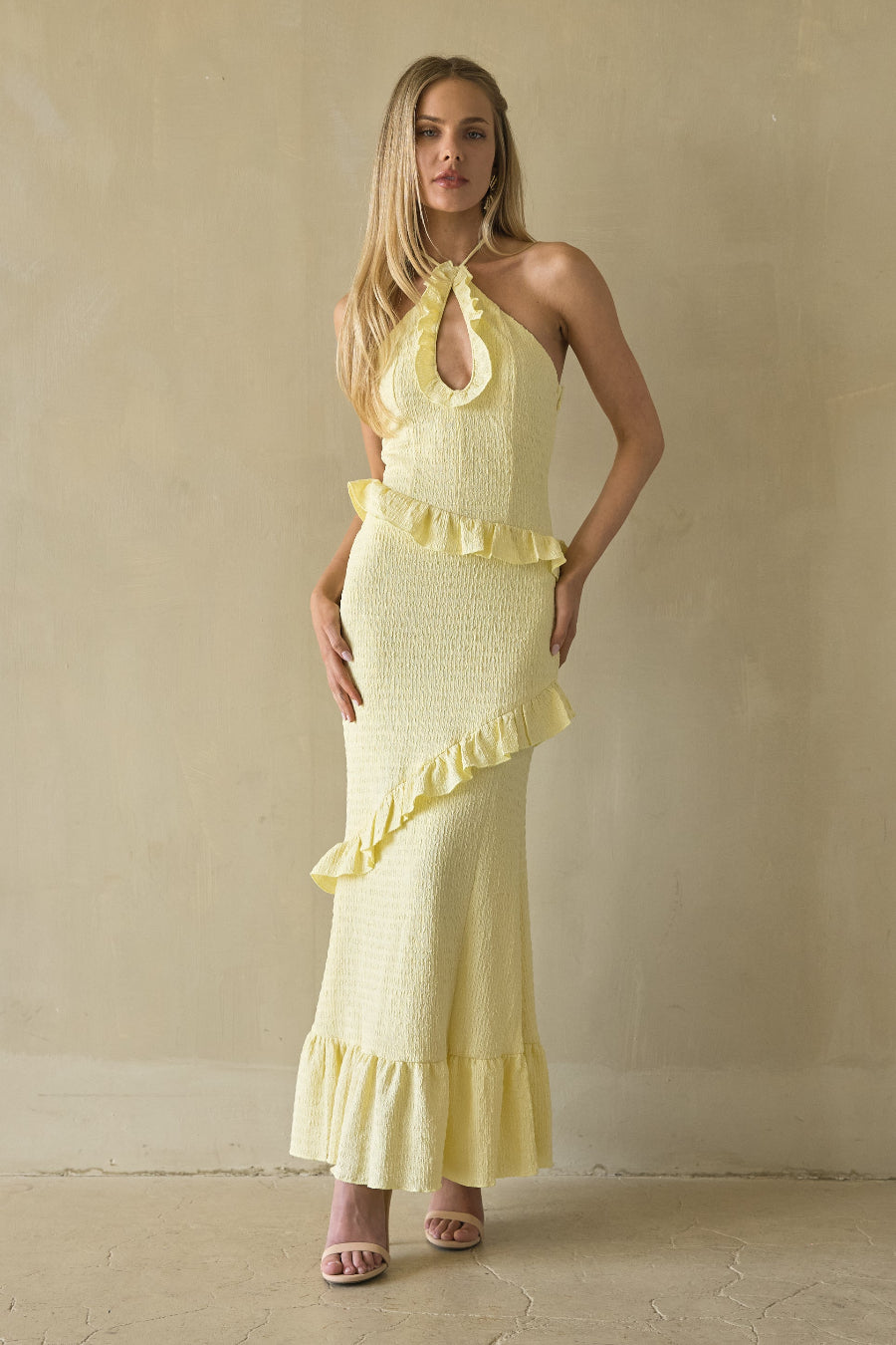 yellow-image | Woman wearing a yellow dress against a beige wall