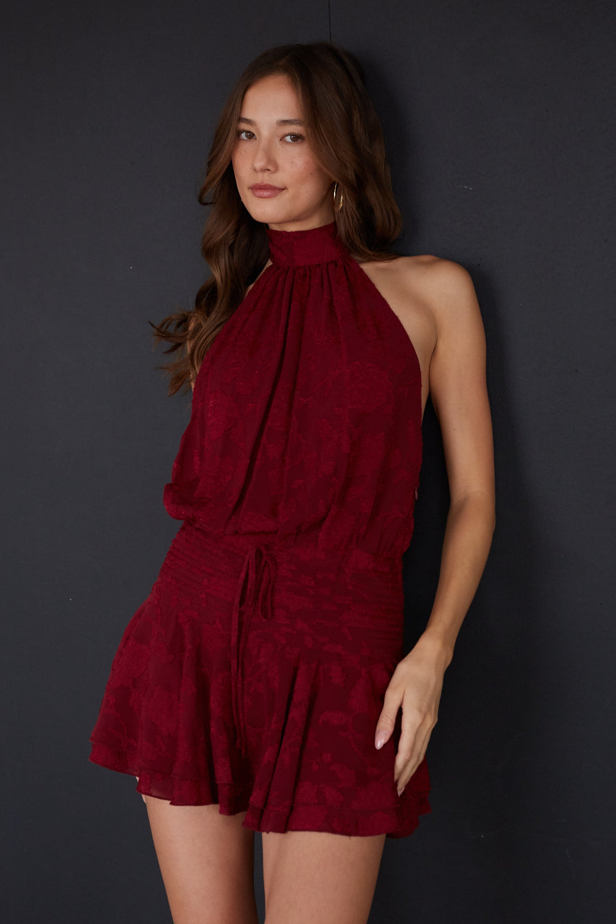 red-image | Woman wearing a red halter dress against a dark background