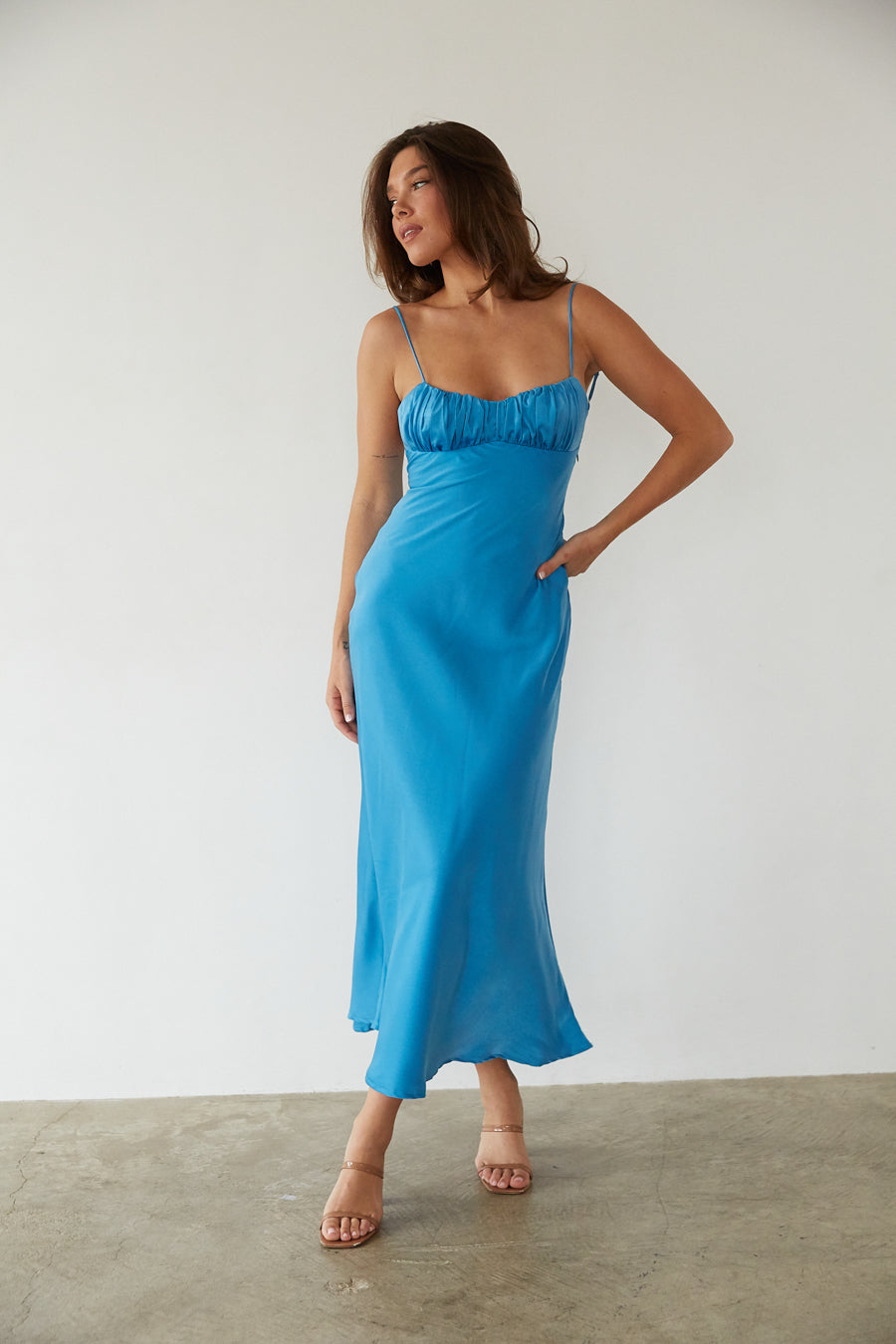 Side-image | Satin Midi Dress | side view showing the smooth light blue satin fabric, flattering silhouette, and flared hemline.