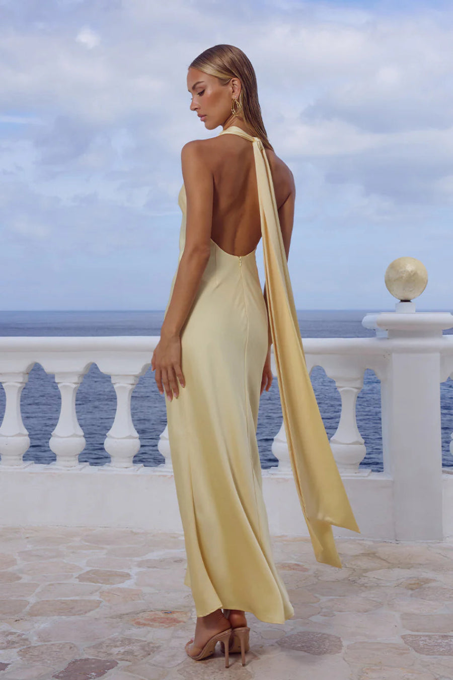 Woman in a yellow dress with a scenic ocean view in the background