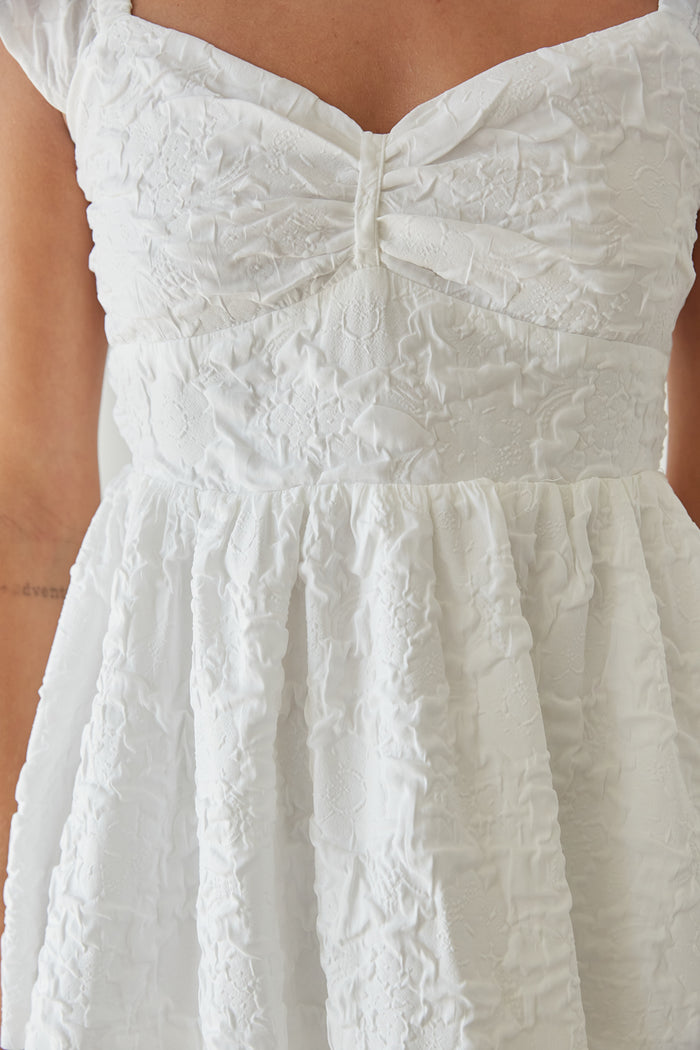 white textured flutter sleeve fit and flare tiered mini dress